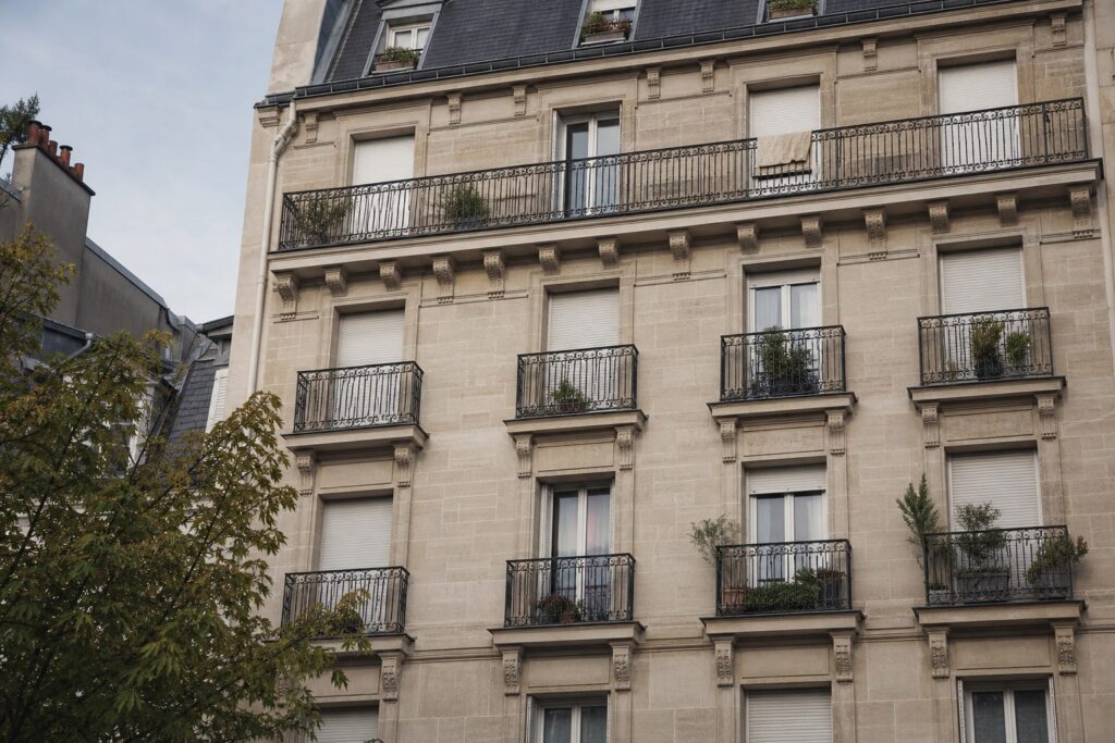 Façade d'immeuble d'habitation ancien avec fenêtres et balcons en fer forgé