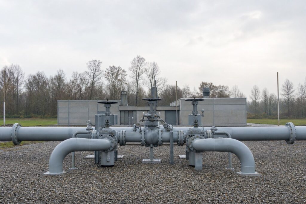 Tuyauteries et vannes métalliques d'un site de stockage de gaz sous un ciel gris d'automne