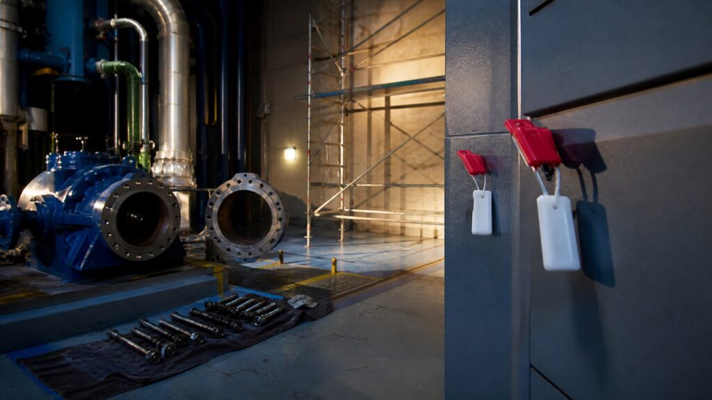 Salle des machines nucléaire en maintenance : pompe primaire démontée, boulons alignés au sol et échafaudage dressé.