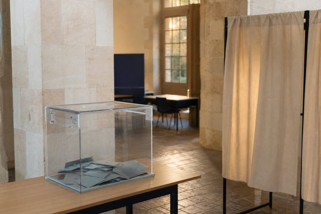 Urne transparente et isoloir dans un bureau de vote