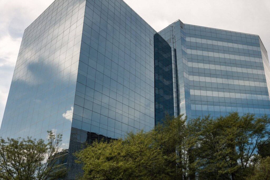 Tour de bureaux moderne à façade de verre reflétant un ciel nuageux
